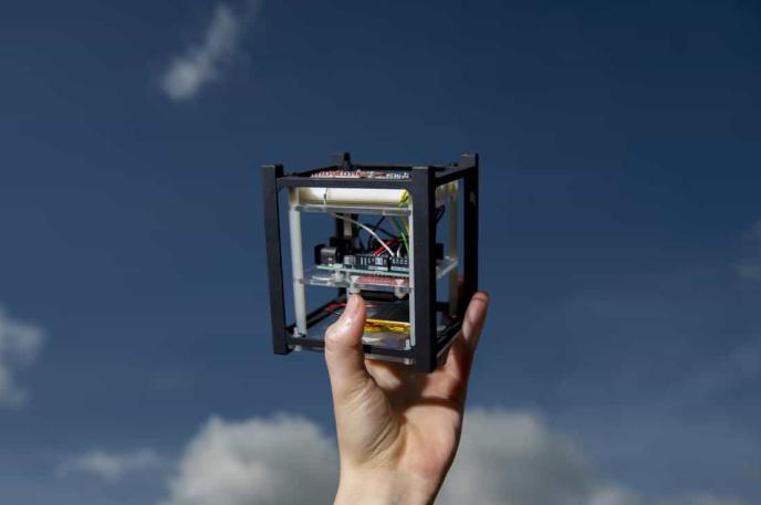 Hand holding a cubesat