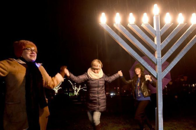 Photo of people dancing around a Hanukkah menorah courtesy of the Chicago Tribune